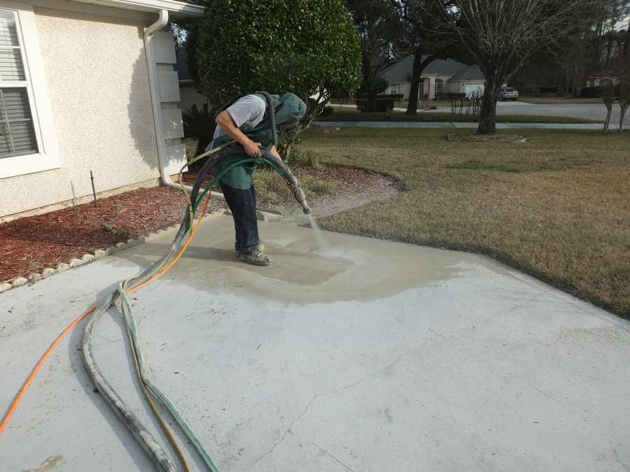 Dustless wet sandblasting paint off a driveway. 